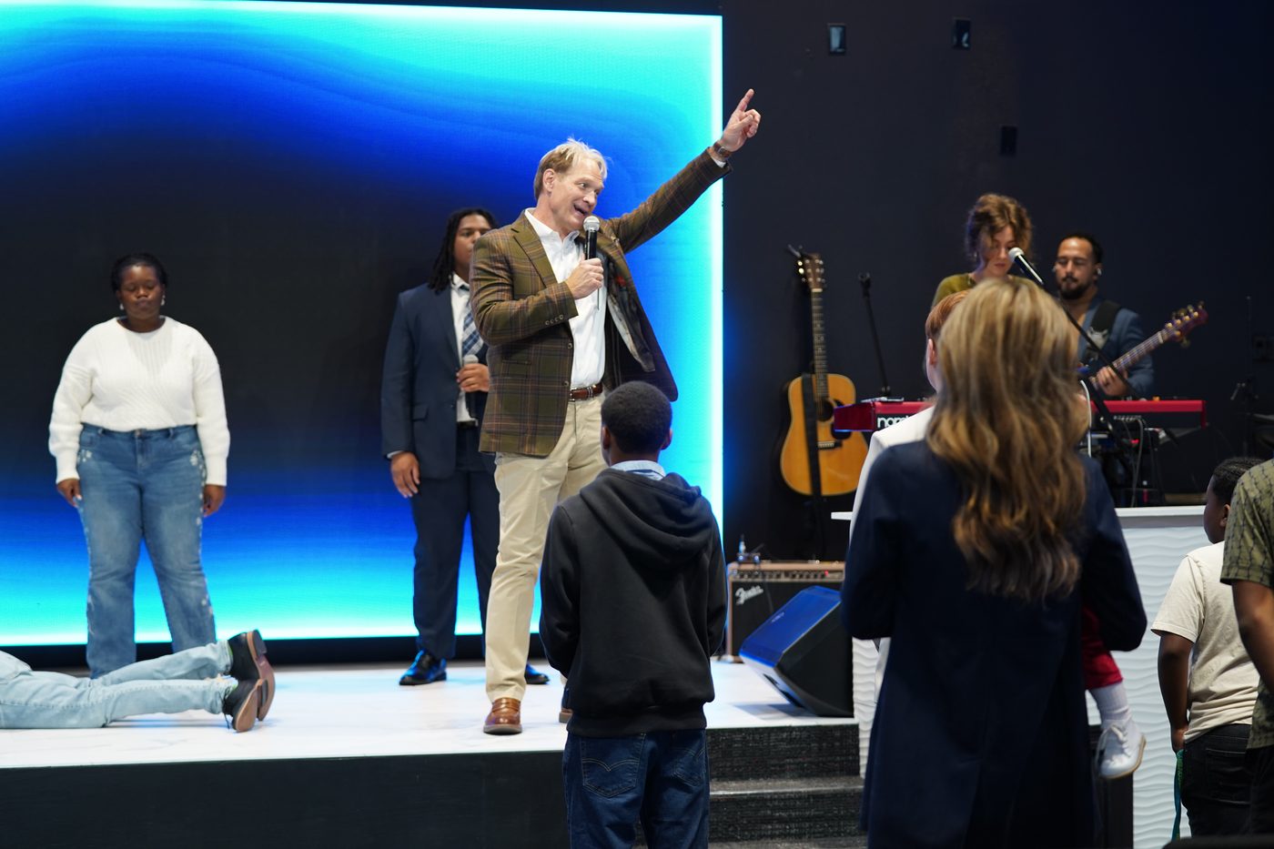 Pastor Stan Pody preaching with his hand raised