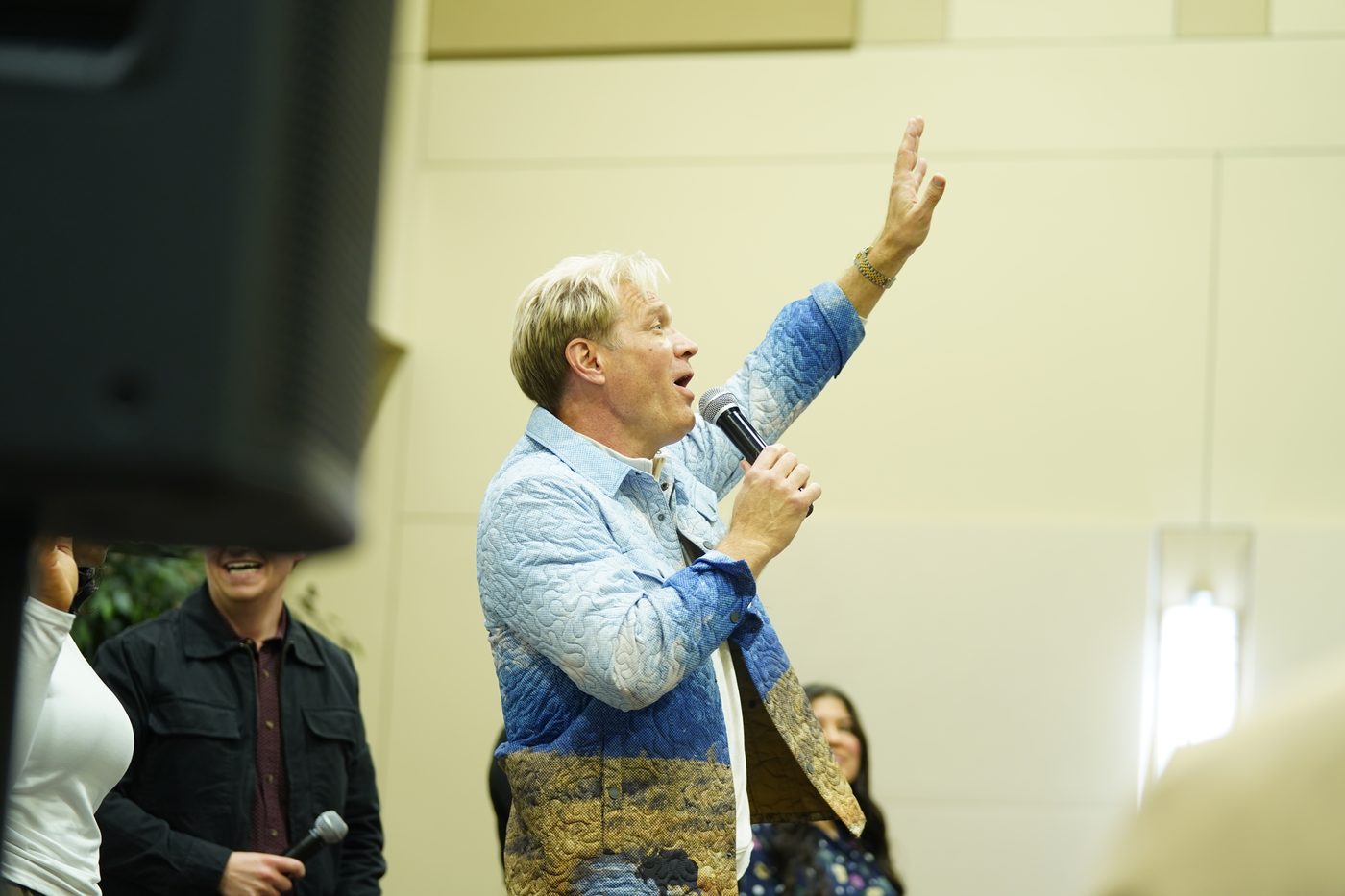 Pastor Stan Pody ministering with his hand raised