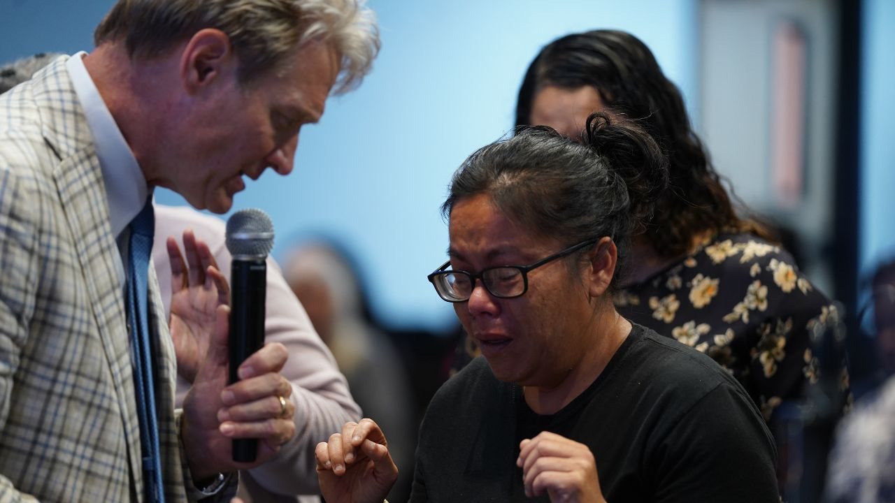 Pastor Stan Pody praying over a woman moved to tears