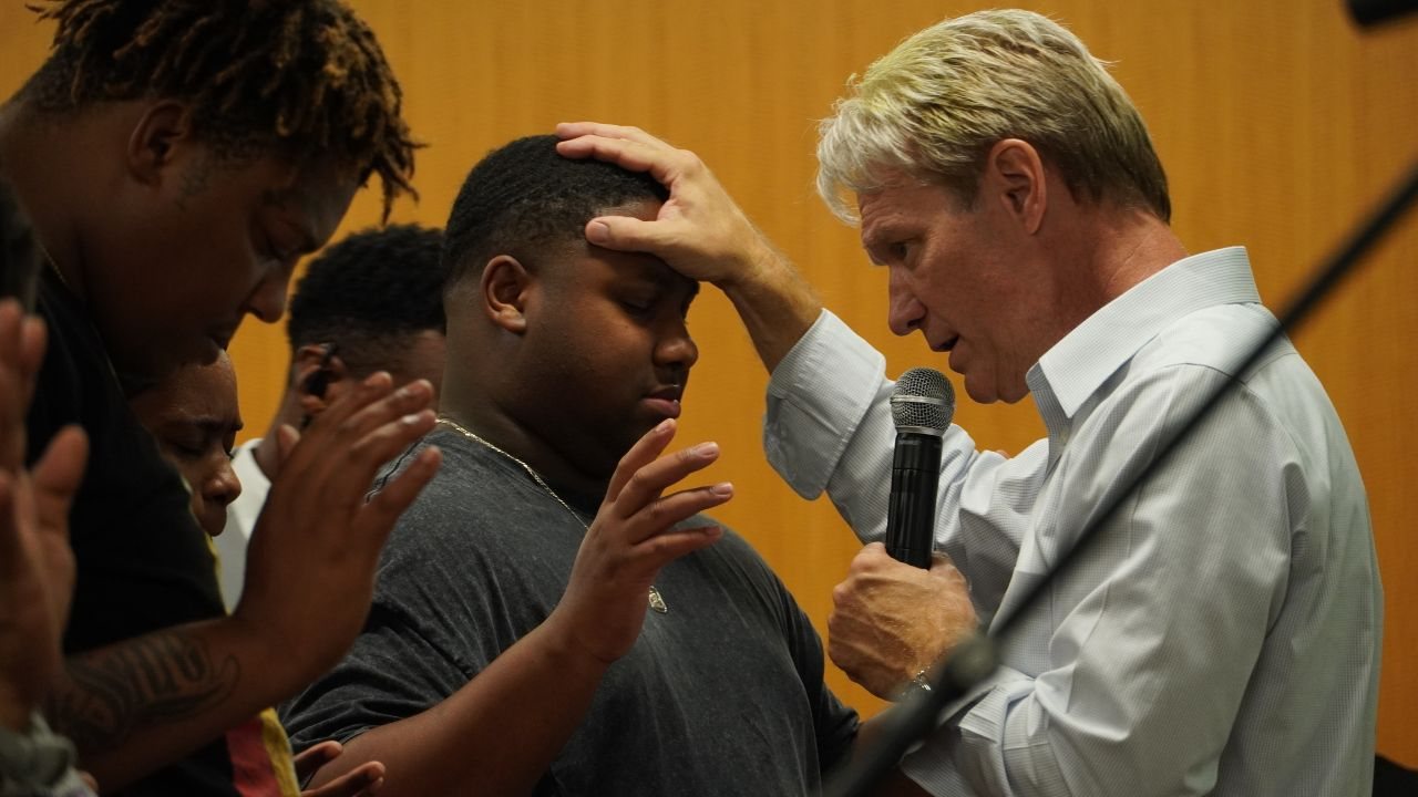 Pastor Stan Pody laying hands on a young man in prayer